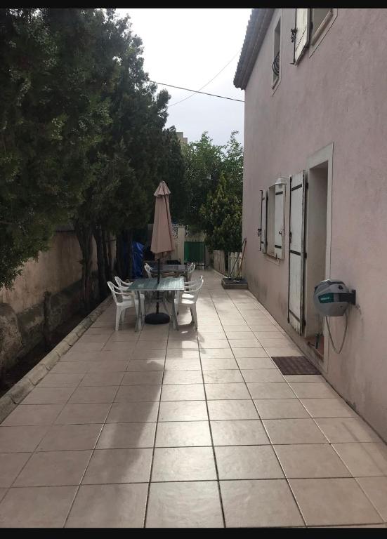 een patio met een tafel en een parasol naast een gebouw bij Maison Sainte Marthe in Marseille