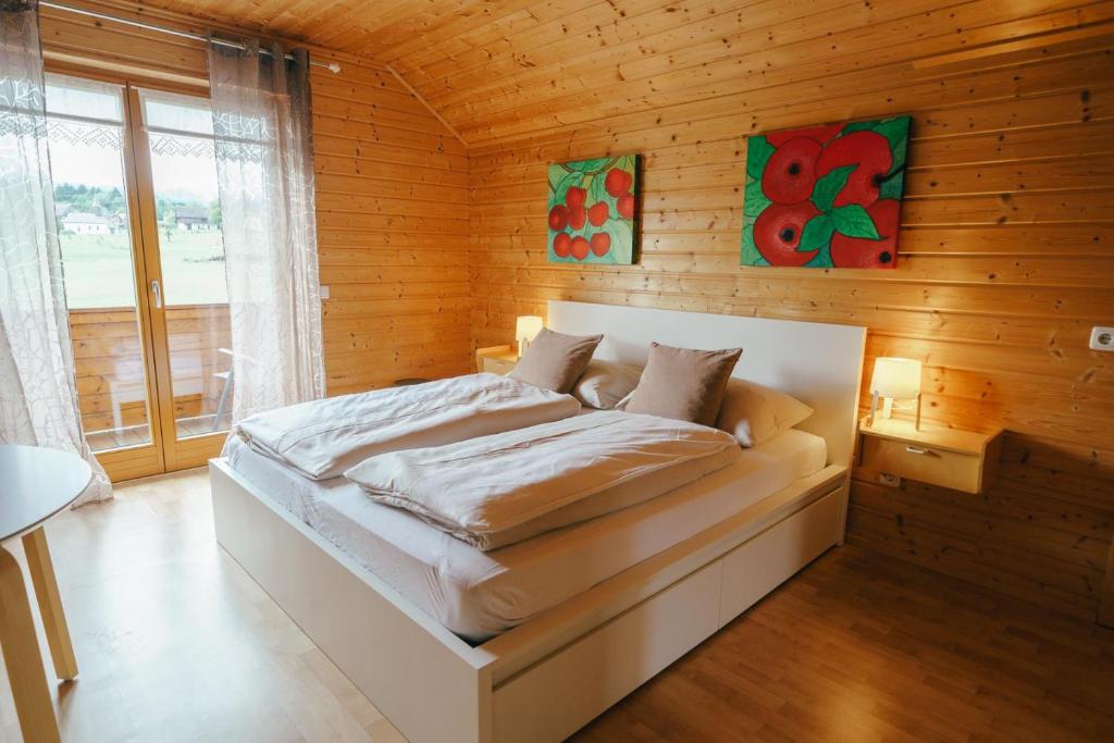 a bedroom with a bed in a wooden wall at Ferienwohnung Karawankenblick in Rosegg