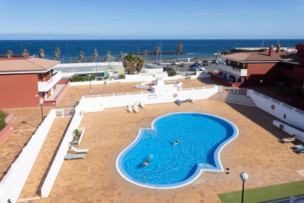 a large swimming pool with the ocean in the background at Home2Book Sea Front Duplex Terrace Pool in Puertito de Güímar