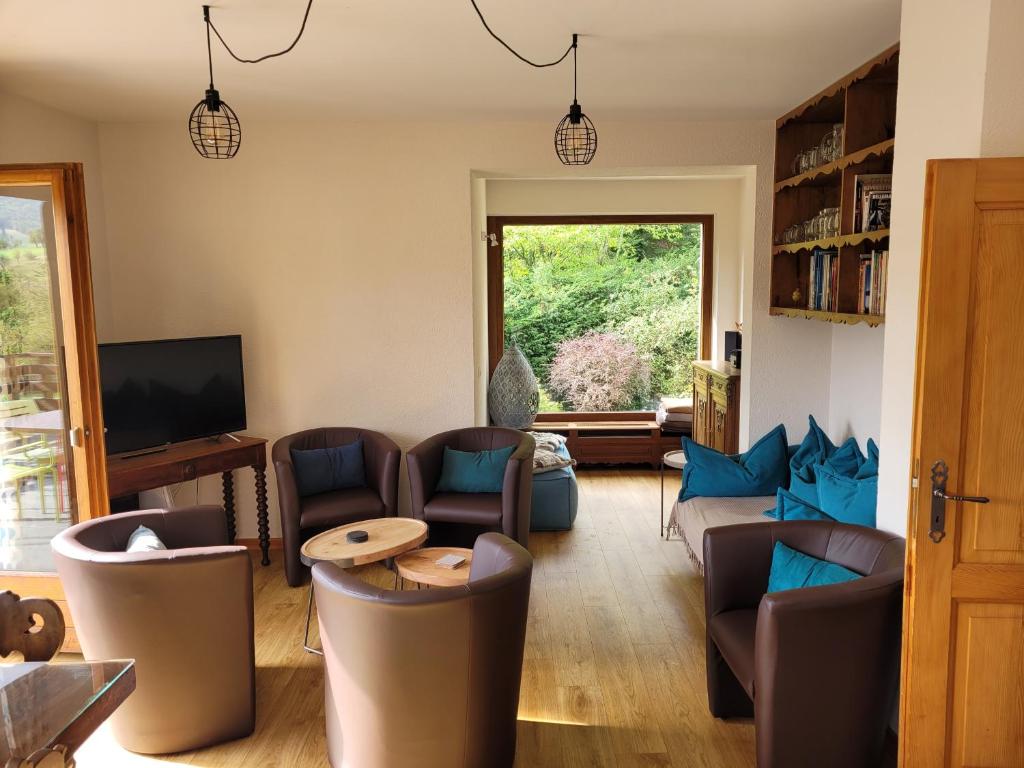 uma sala de estar com sofás e cadeiras e uma televisão em Le Breit Maison De Charme Avec Sa Dependance em Breitenbach