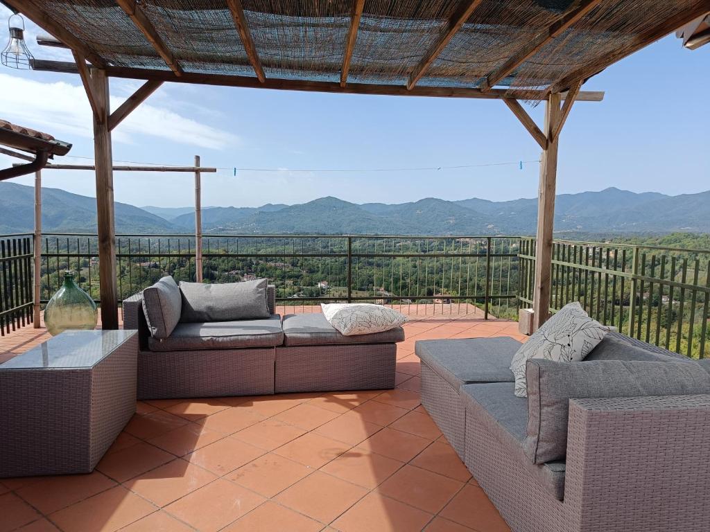 um pátio com sofás e vista para as montanhas em Olivola : maison entière dans un cadre magnifique em Olivola
