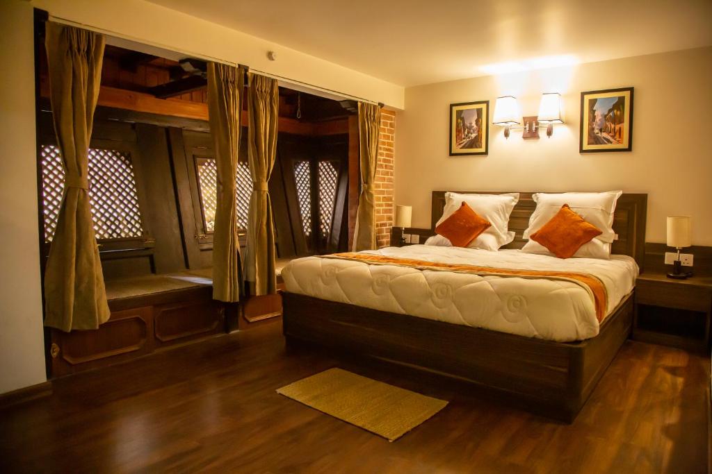 - une chambre avec un grand lit et une fenêtre dans l'établissement Hotel Traditional, à Bhaktapur