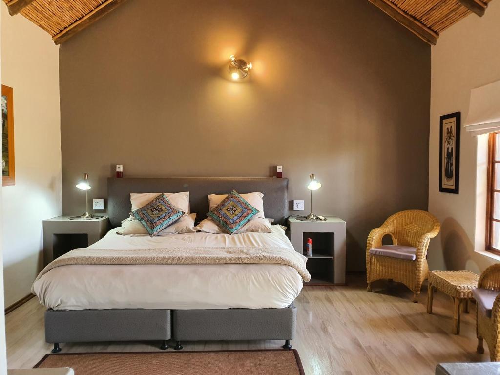 a bedroom with a large bed with two night stands at Thabile Lodge in Oudtshoorn