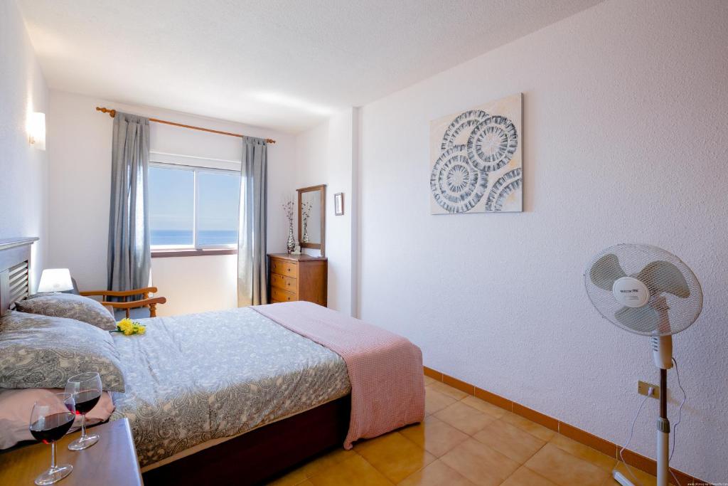 sypialnia z łóżkiem, wentylatorem i oknem w obiekcie FRONT LiNE OCEAN ViEW 2BeD Wi-Fi YOUR HOLiDAY HOME w mieście Puerto de Santiago