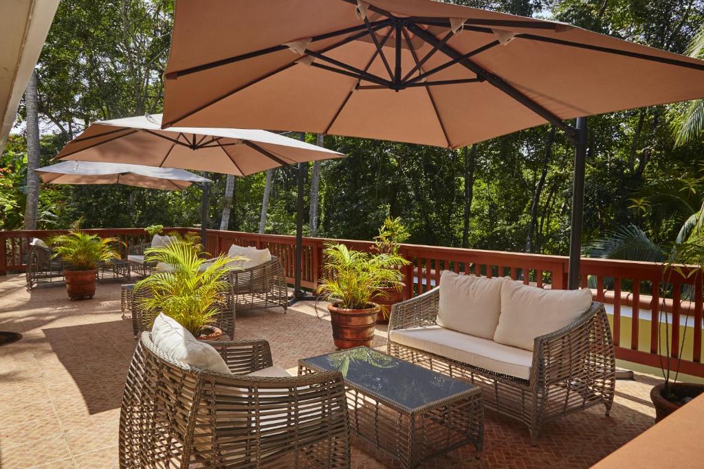 a patio area with chairs, tables and umbrellas at Contadora Island Inn in Contadora
