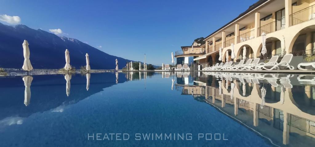 a reflection of buildings and chairs in a body of water at Hotel Mercedes in Limone sul Garda