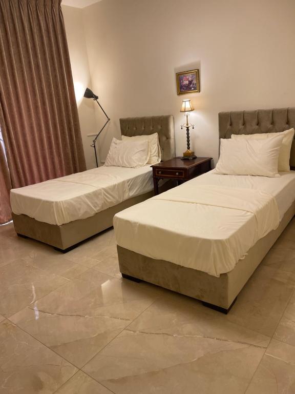 two beds sitting in a hotel room with at A Luxury 2 Bedroom With a perfect location in Sweifiyeh in Amman