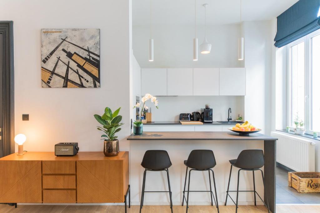 a kitchen with two bar stools and a counter at Appartement Guillemins Station Terrace in Liège