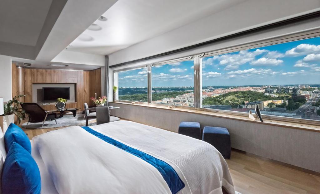 SKY SUITE HOTEL في براغ: غرفة نوم بسرير كبير ونافذة كبيرة