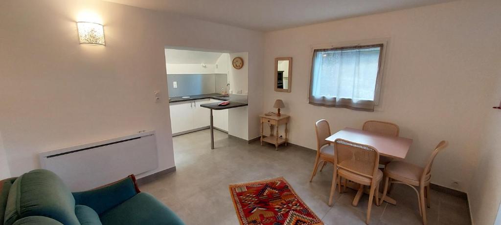 ein Wohnzimmer mit einem Sofa und einem Tisch sowie eine Küche in der Unterkunft T2 indépendant dans maison Tout confort in Die