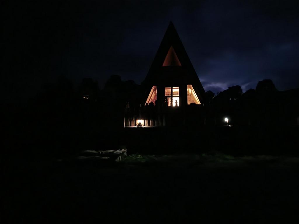 a church at night with its lights on at A Pine vikendica u srcu Zapadne Srbije in Nova Varoš