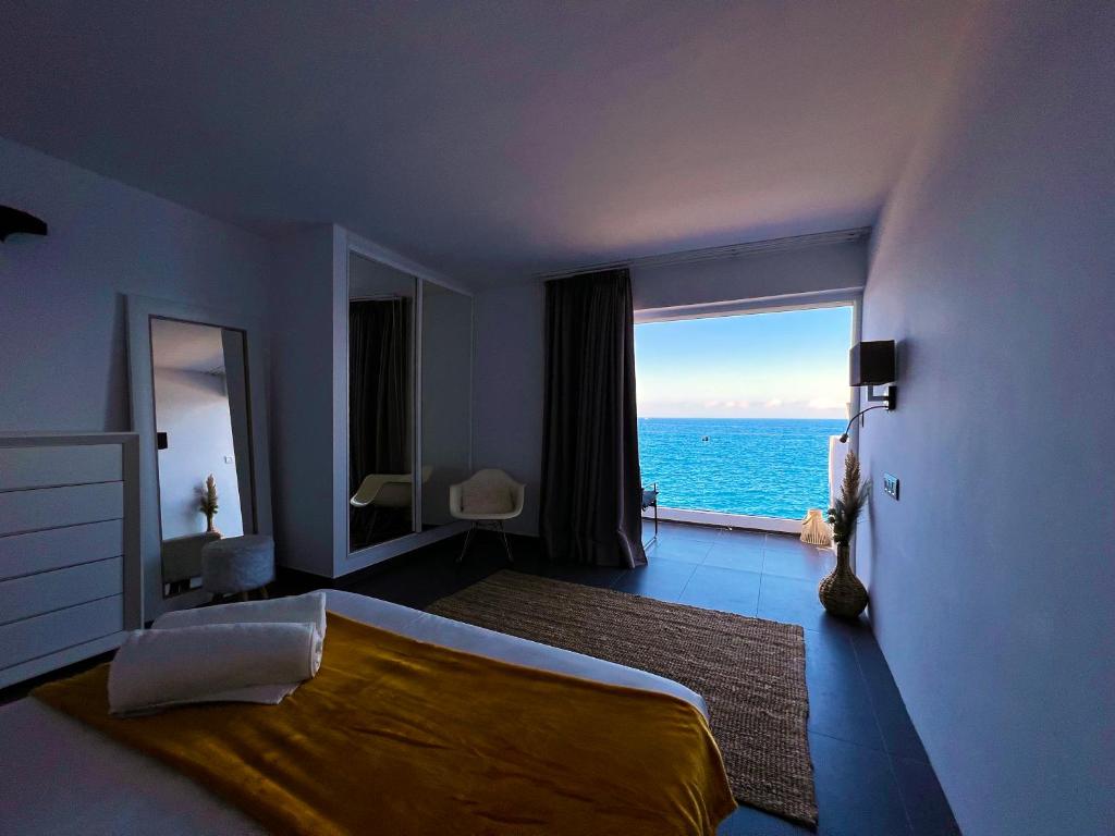 Schlafzimmer mit einem großen Bett und Meerblick in der Unterkunft At the ocean’s edge in Callao Salvaje