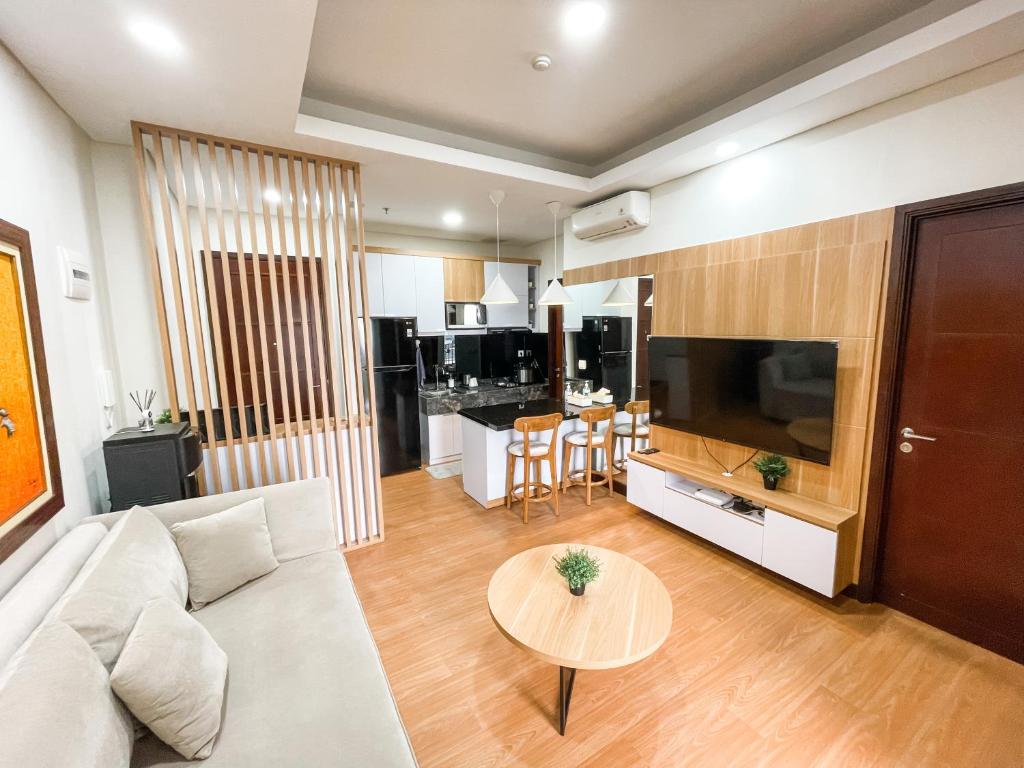 a living room with a couch and a table at 2 Bedrooms Permata Hijau Suites Apartment in Jakarta
