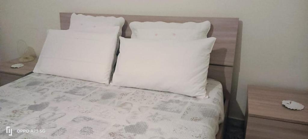 ein Bett mit zwei weißen Kissen in der Unterkunft B&B LEO'S in Cagliari