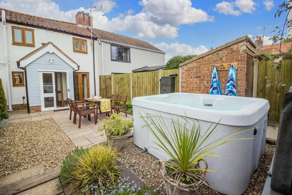 a bath tub in the backyard of a house at Beautiful 04 Berth Cottage With A Private Hot Tub In Norfolk Ref 99002hc in Pentney