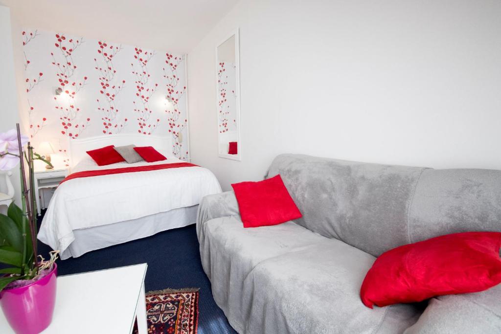 a living room with a couch and a bed at Hotel Biney in Rodez