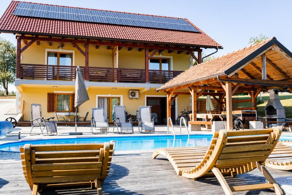 a villa with a swimming pool and a house at Lahinja & Kolpa river apartments in Metlika