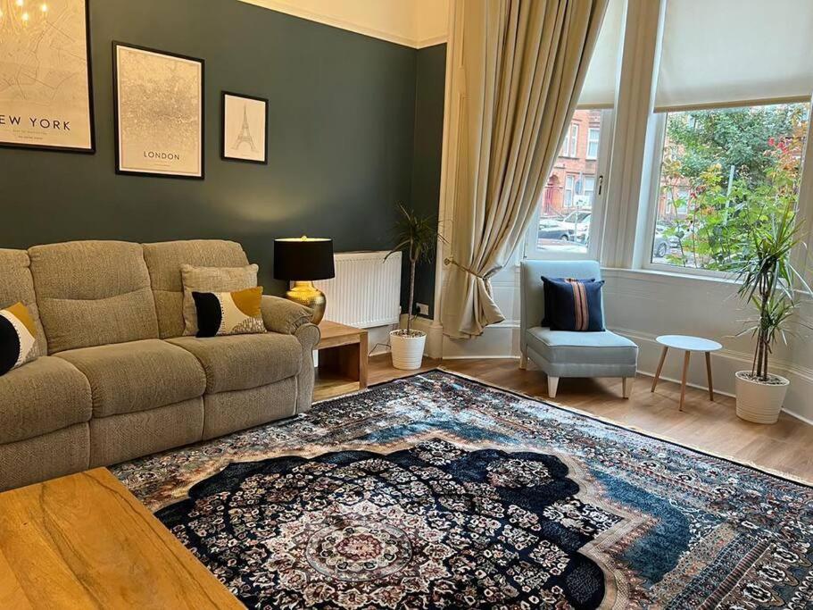 a living room with a couch and a rug at Victorian 3 BR main door flat, King size beds , large rooms in Glasgow