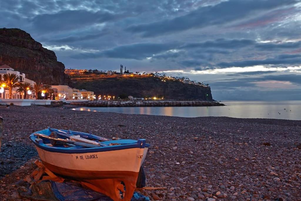 a small boat sitting on a rocky beach at Casas Galloway - Playa Santiago Sol y descanso in Playa de Santiago