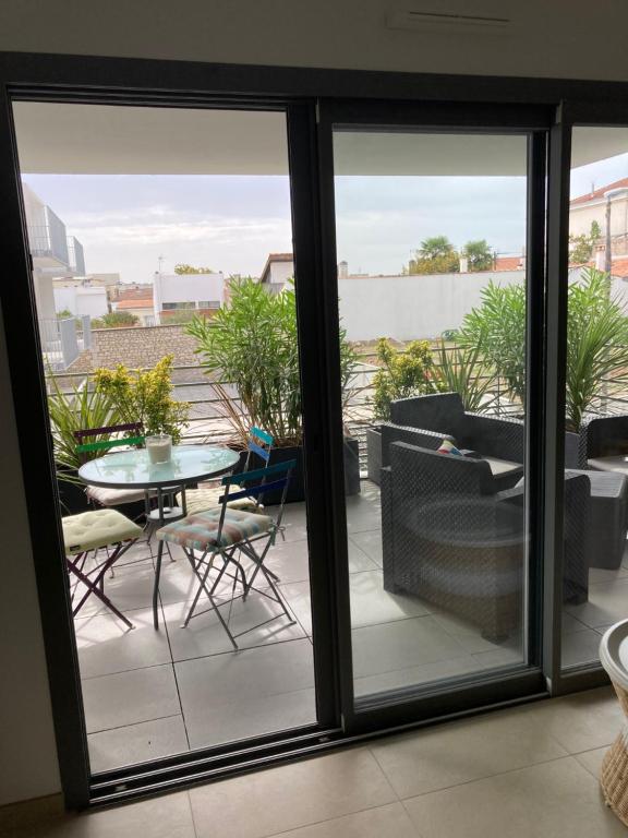Habitación con vistas a un balcón con mesa y sillas. en Joli appartement coquet et cosy, en Royan