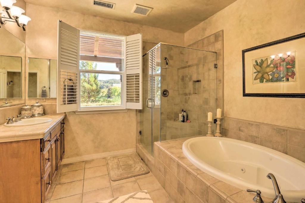 uma casa de banho com uma banheira, um chuveiro e um lavatório. em Incredible Templeton Retreat with Private Pool! em Templeton