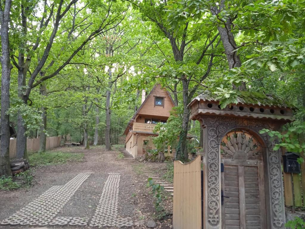 ein Tor vor einem Haus in einem Wald in der Unterkunft Őzike-Lak a Börzsönyben in Kismaros