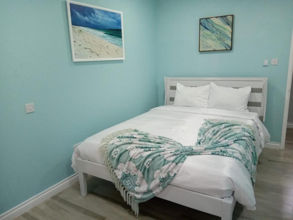 Un dormitorio con una cama blanca con una manta. en JemmRose Suites en Choc