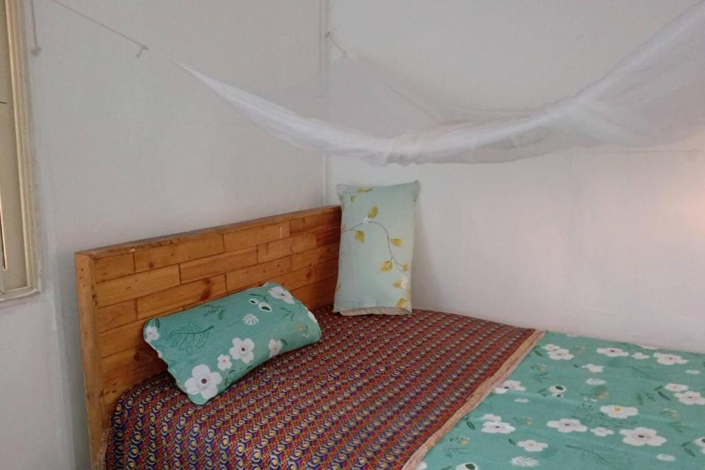 a small bedroom with a bed and a pillow at Beach House in Kigamboni Dar es Salaam in Dar es Salaam