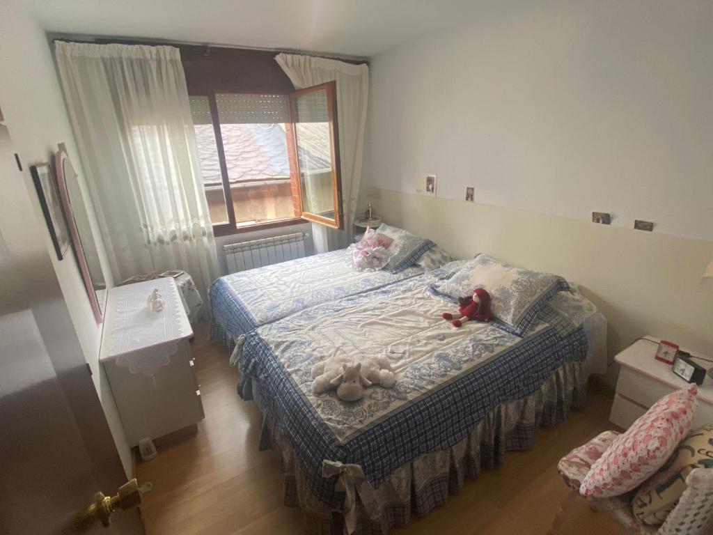una camera da letto con un letto con sopra degli animali di peluche di Dúplex en el centro del pueblo, muy bien comunicado a Puigcerdà