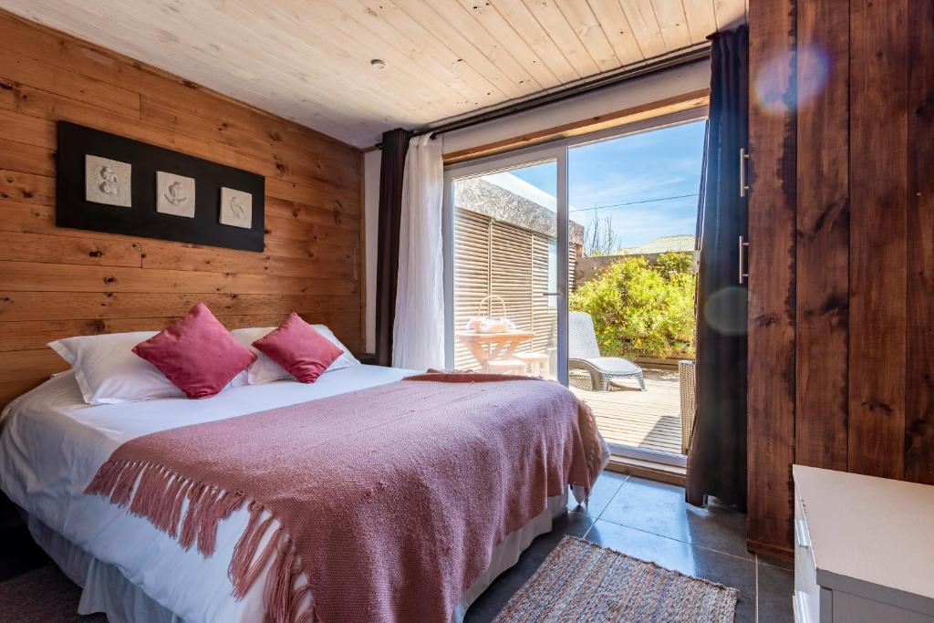 1 dormitorio con cama y ventana grande en Pichilemu Apart Hotel, en Pichilemu