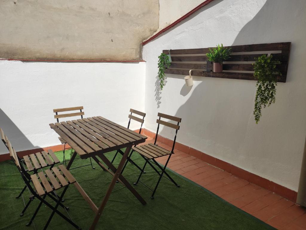 にあるApartamento rural Casa Caloの木製テーブルと椅子付きのパティオ