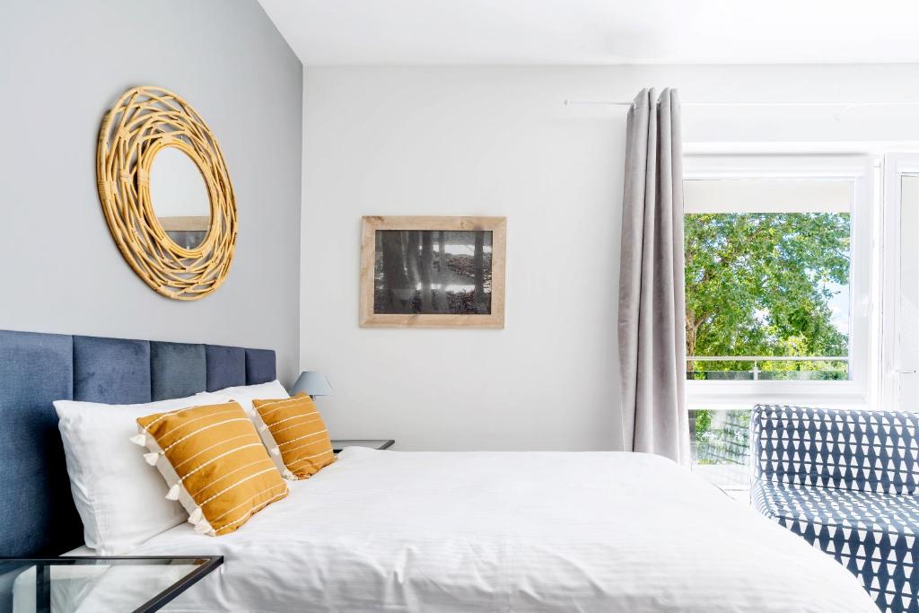 a bedroom with a bed with yellow pillows and a mirror at Apartament UKIEL PARK 30 przy Plaży Miejskiej - klimatyzacja,free parking,FV in Olsztyn