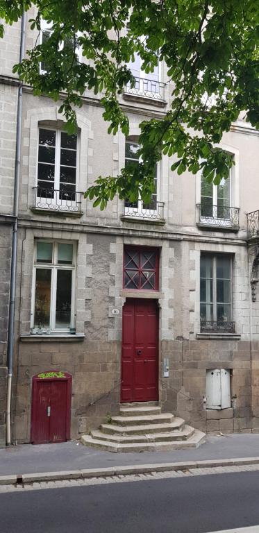 a brick building with a red door and stairs at Nantes panoramique in Nantes