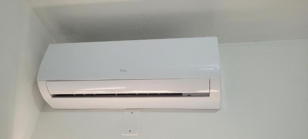 a white microwave oven hanging from a ceiling at Suítes Privativas em Guriri in Guriri