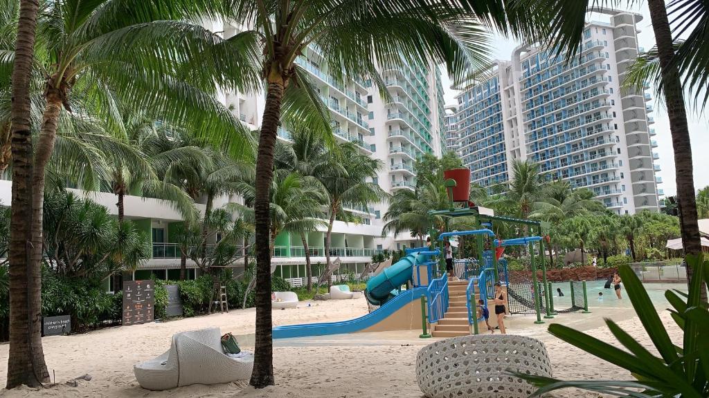 a playground on the beach with palm trees and buildings at Azure Urban Resort in Manila