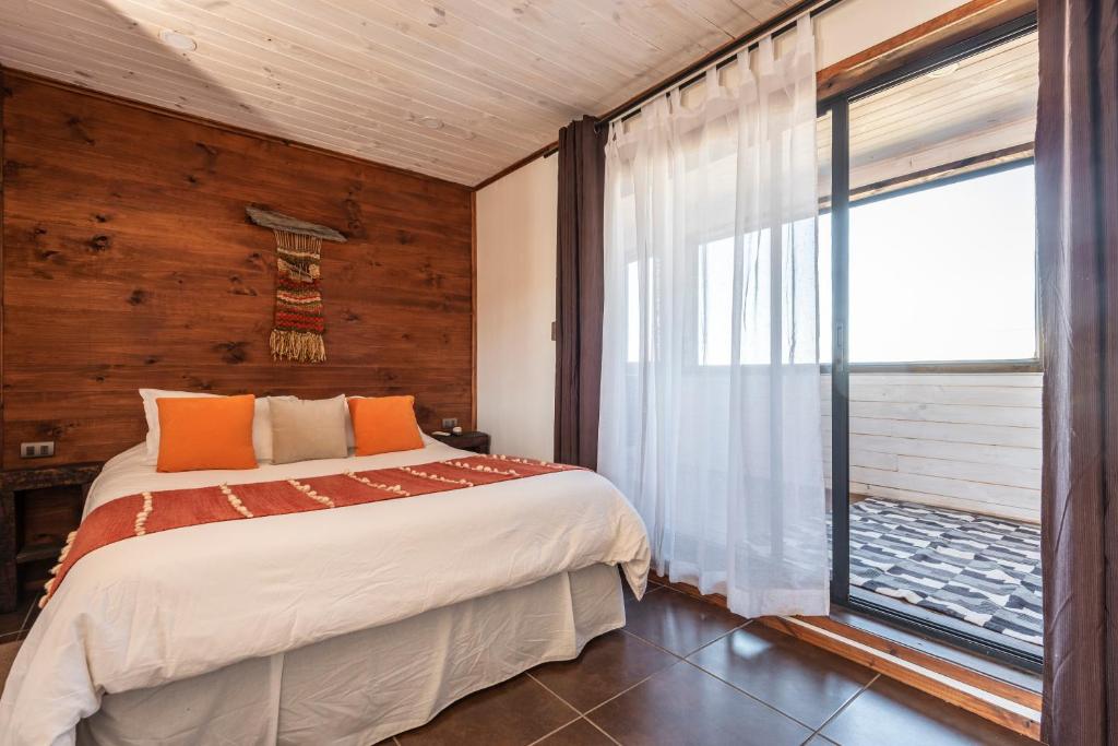 una camera da letto con un letto e una grande finestra di Pichilemu Apart Hotel a Pichilemu