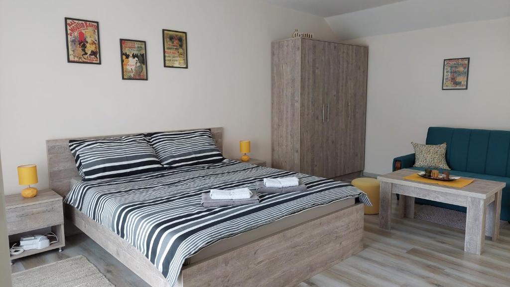 a bedroom with a large bed and a table at Apartmani MALINA in Vrnjačka Banja