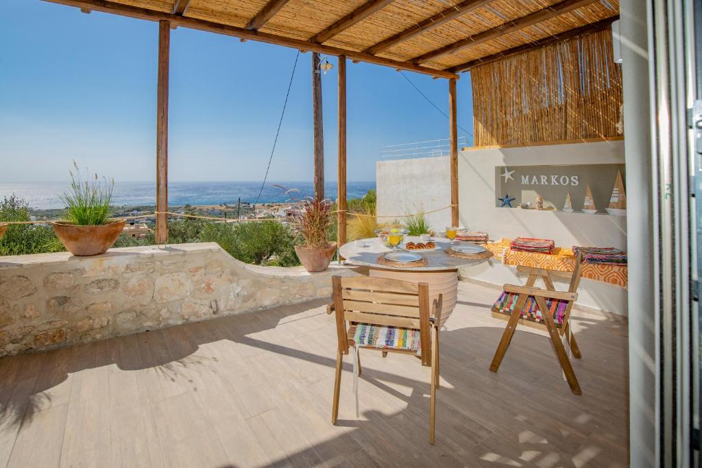 a patio with a table and chairs and a view of the ocean at Markos Home in Koutsounari