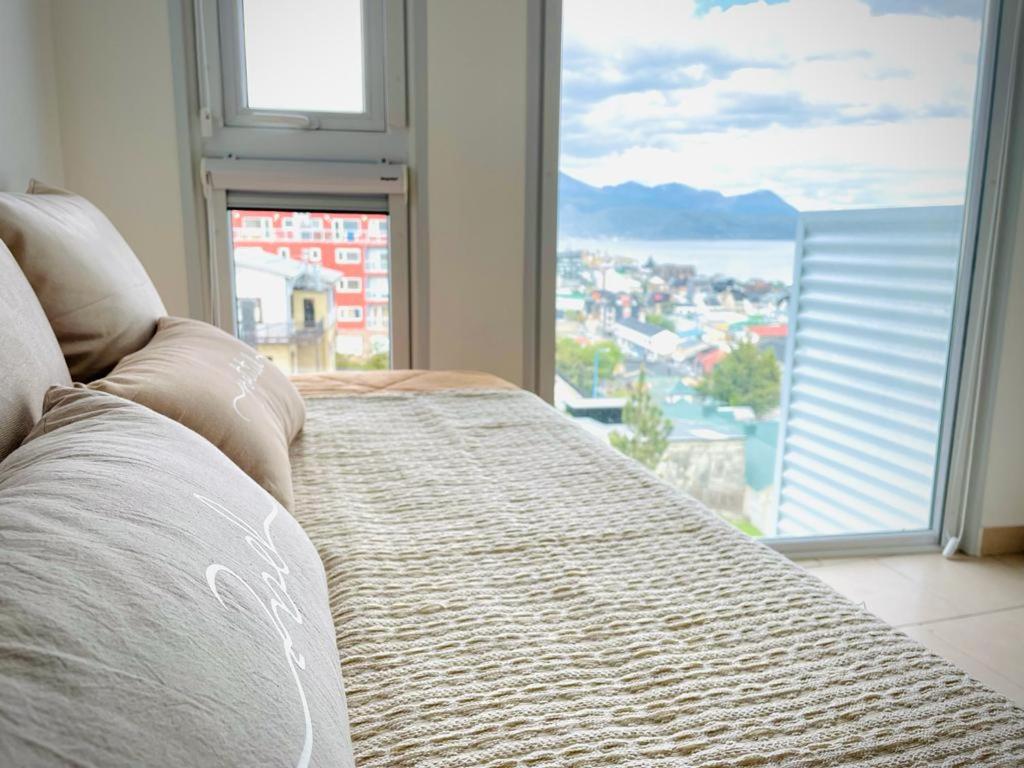 a bed in a room with a large window at Infinity View 3-4 in Ushuaia