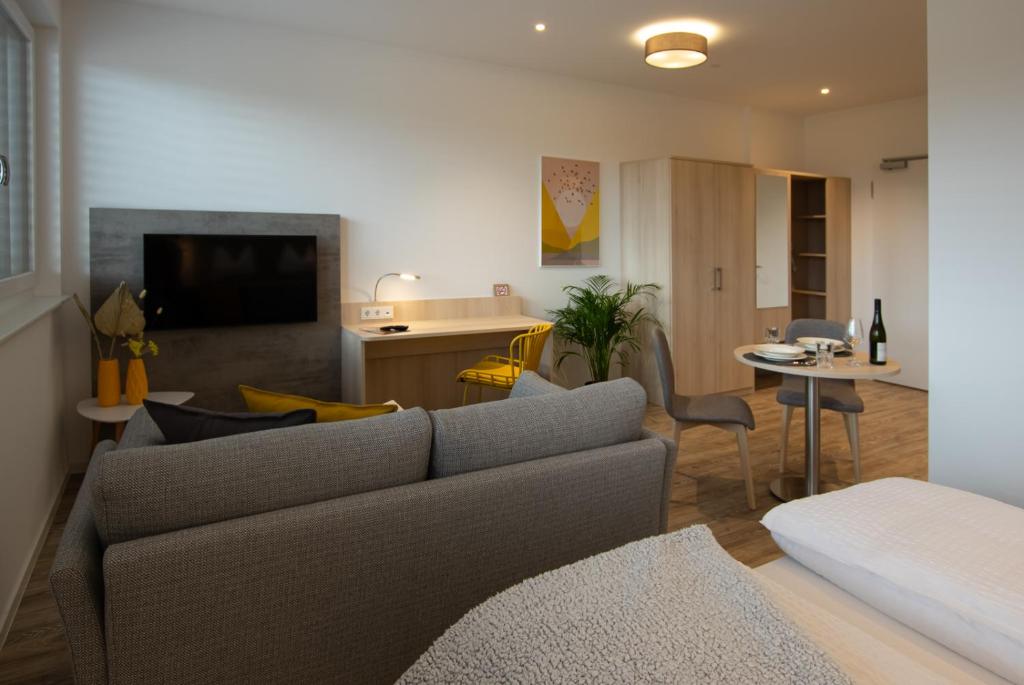 ein Wohnzimmer mit einem Sofa und einem Esszimmer in der Unterkunft Livin63 Studio Apartments in Hösbach