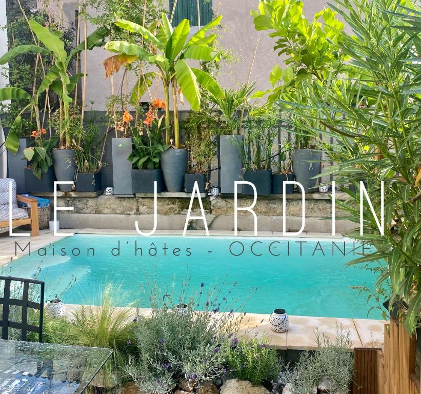 un letrero para un jardín con plantas y una piscina en Le Jardin, en Aspiran