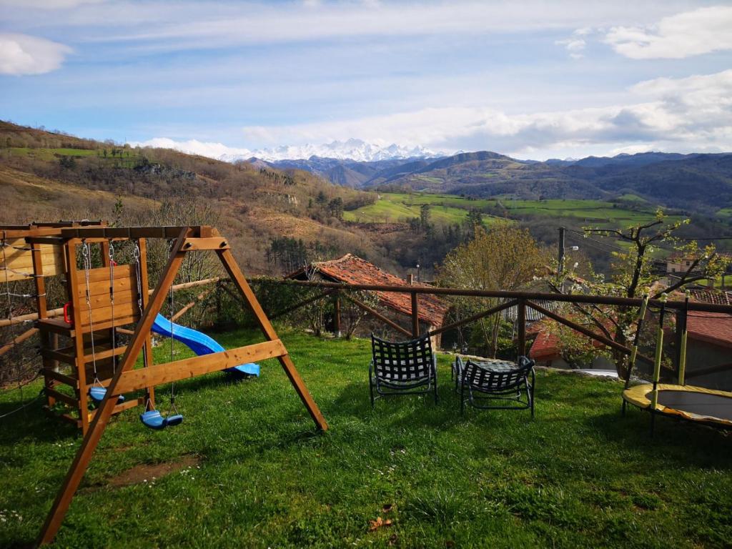 a playground with two chairs and a swing at La casina del Cabrajigo in Cangas de Onís