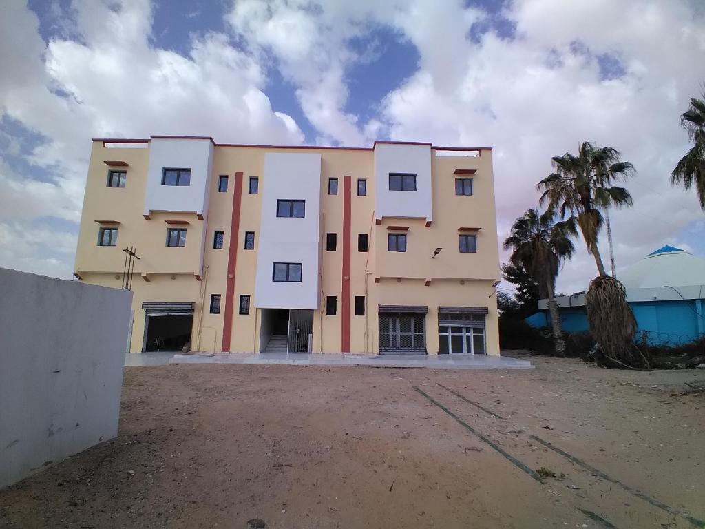 a building with palm trees in front of it at النسيم Nessim in Nouakchott