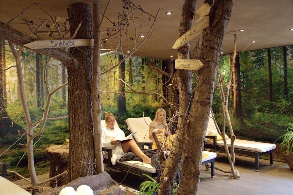 two women sitting in chairs in the woods at Landhotel Am Rothenberg in Uslar