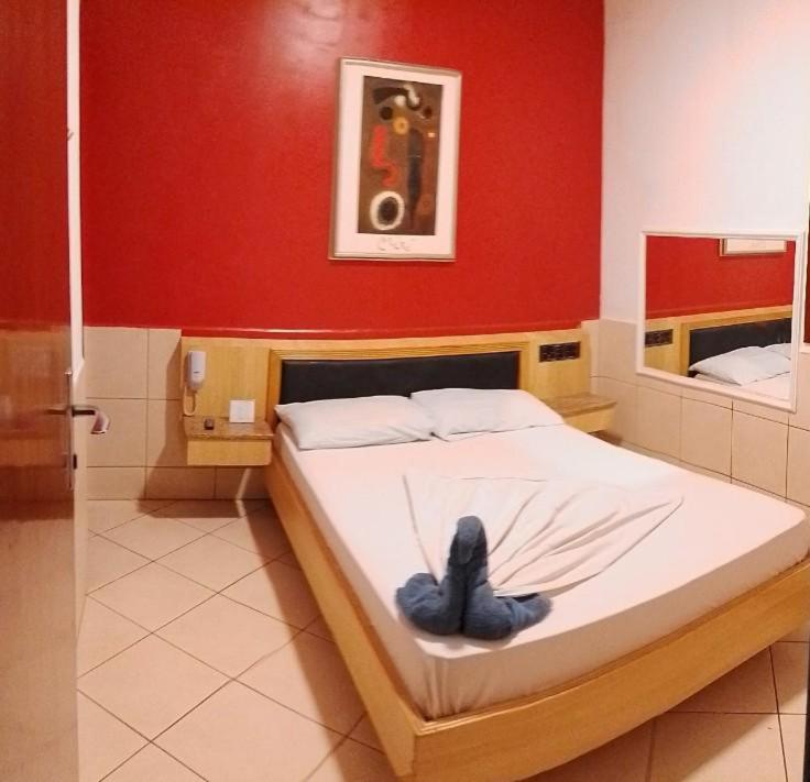 Posto letto in camera con parete rossa. di Hotel Smart Inn a San Paolo