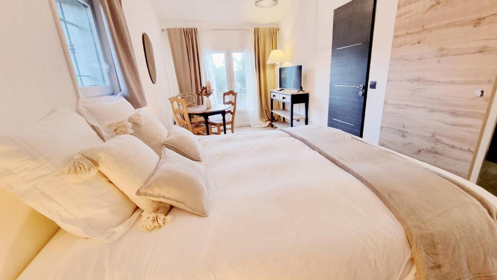 a bedroom with a large white bed and a table at Suite Oasis en Provence Luberon Pierrevert in Pierrevert