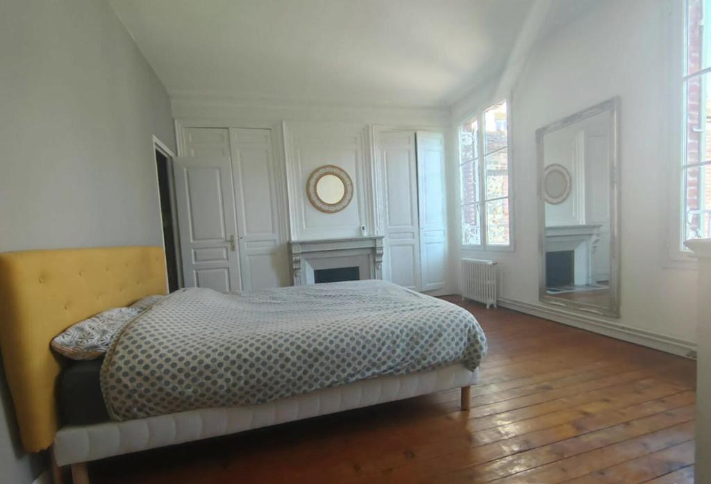 a white bedroom with a bed and two windows at Maison de maître, un coin de verdure en hyper centre in Lisieux