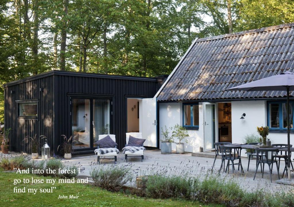 ein schwarzweißes Haus mit einer Terrasse in der Unterkunft Bokis - Modern Forest Cottage in Brösarp