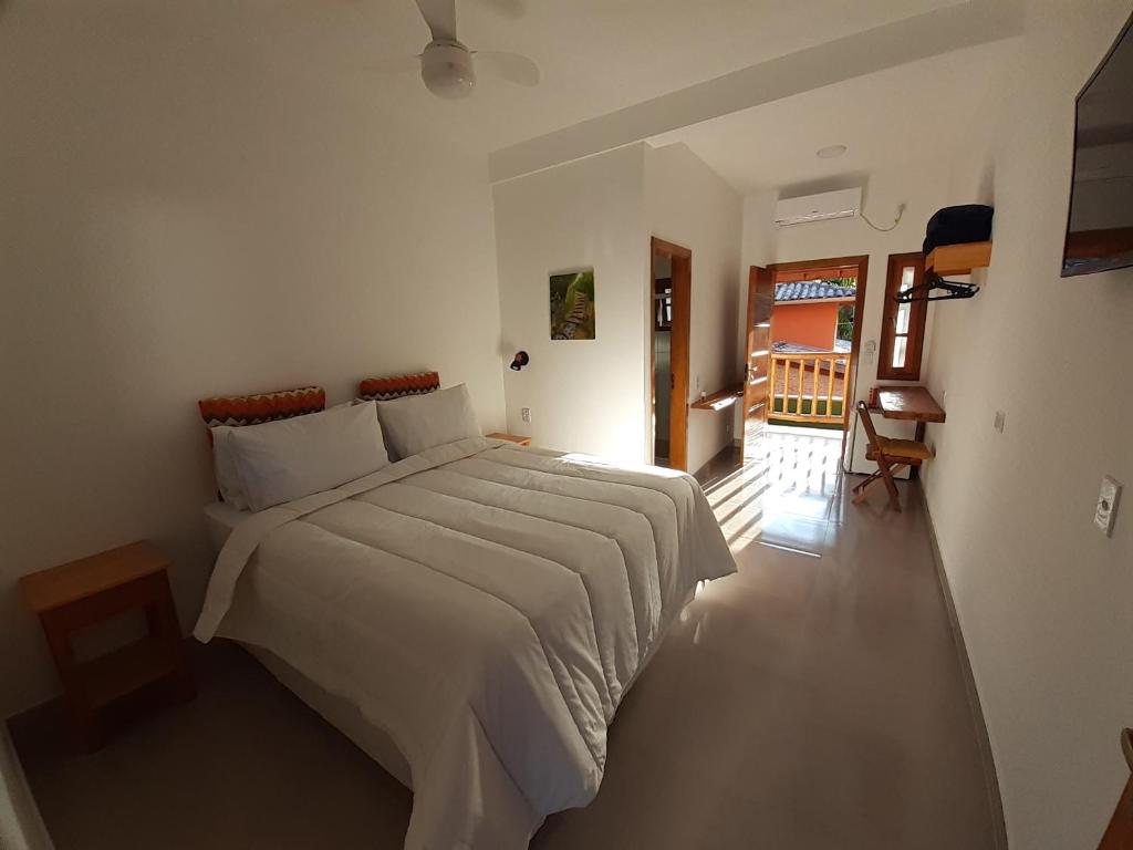 een slaapkamer met een groot wit bed in een kamer bij Caminho da areia in Ubatuba