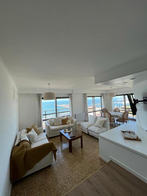 Los Petos - Playa Grande في مار ديل بلاتا: غرفة معيشة بأثاث أبيض وإطلالة على المحيط